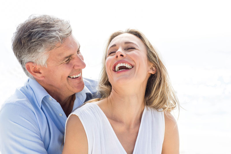 dental patients smiling with each other because they have been treated with restorative zirconia dental implants.