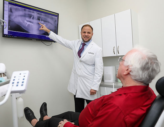 dr alex planes during an all on four dental implant consulation in office