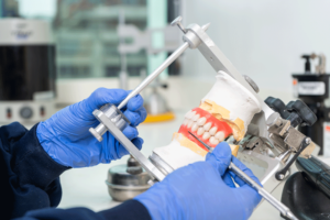 a picture of a dentists hands holding an All-On-4 dental implant after it has been milled.